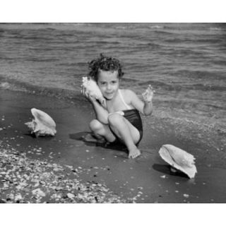 Girl holding a conch shell near her ear on the beach Poster Print (18 x 24)